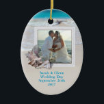 Beach Wedding Keepake Foto Ornament<br><div class="desc">Halten Sie Hochzeitsschmuck mit einem Strandthema. Fügen Sie diesem ovalen, Keramik-Ornament ein Bild hinzu und passen Sie es mit Text auf beiden Seiten an. Tropische Muscheln schmücken den Rahmen und das Hintergrundbild ist das Meer Wasser und Strand Sand. Platzieren Sie Namen, Hochzeitsdatum auf der Vorderseite und Zielort auf der Rückseite....</div>