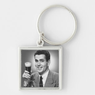 Bemannen Sie das Halten des Glases Bieres im Schlüsselanhänger