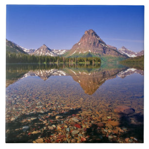 Berge spiegeln sich im ruhigen Two Medicine Lake i Fliese