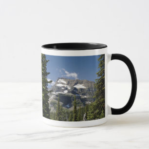 Bergspitze zwischen Bäumen unter einem blauen Tasse