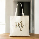Black Gold Modern Script Monogram Name Tragetasche<br><div class="desc">Tragen Sie Ihre Essentials stilvoll mit dem Black and Gold Modern Script Monogram Name Tote Bag ein. Mit einer schlichten schwarzen Leinwand mit einem fett-goldenen Monogramm in einem modernen Script-Schriftart verbindet diese Tote-Tasche Eleganz und Funktionalität. Er ist groß genug zum Einkaufen, Arbeiten oder zur täglichen Nutzung und bietet sowohl Stil...</div>