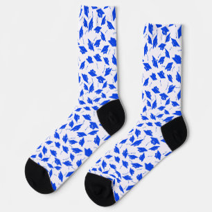 Blaue Graduierungskappen in die Luft geworfen Socken