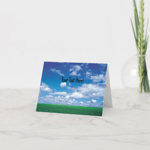 Blaue Himmel mit flauschigen Wolken und grüner Gra Karte