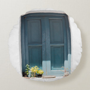 BLAUE HOLZTÜR AUF DER WEISSEN KONKRETEN WAND RUNDES KISSEN