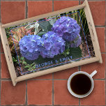 Blaue Hydrangea Garden Bildvorlage Serviertablett<br><div class="desc">Hübsches Serviertablett aus Blumenholz mit Hydrangea-Blume und ein Ort für Ihren Text. Lila bläuliche Hydrangea-Blüten sind das zentrale Bild eines tropischen Gartens. Andere farbenfrohe Pflanze und Blätter im Hintergrund machen dies zu einem interessanten Unterbild für braune oder schwarze Holzfächer. Eine Textzeile am Ende des Fotos kann für Namen oder andere...</div>