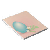 Blaue Osterei bei Blume und Blätter Notizblock (angewinkelt)