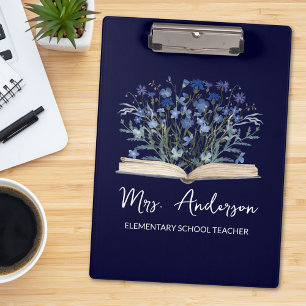 Blaue Wildblumen wachsen aus dem Buch Lehrer Klemmbrett