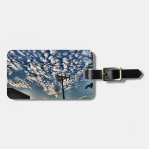 Blauer Himmel mit Wolken, die in Schatten geraten Gepäckanhänger