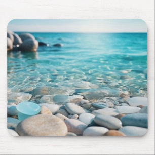 Blauer Ozean mit Meeresglas und Steinen am Strand Mousepad