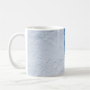 Blauer und schwarzer Blumenschal auf weißem Sand Kaffeetasse