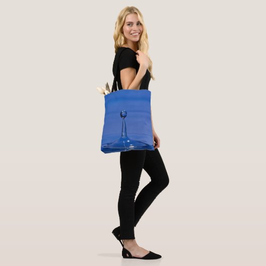 Blauer Wassertropfen in Bewegung auf einer Tasche (Am Model)