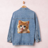 Blaugäugiges Kätzchen leckt Pfote Jeansjacke (Hangar)