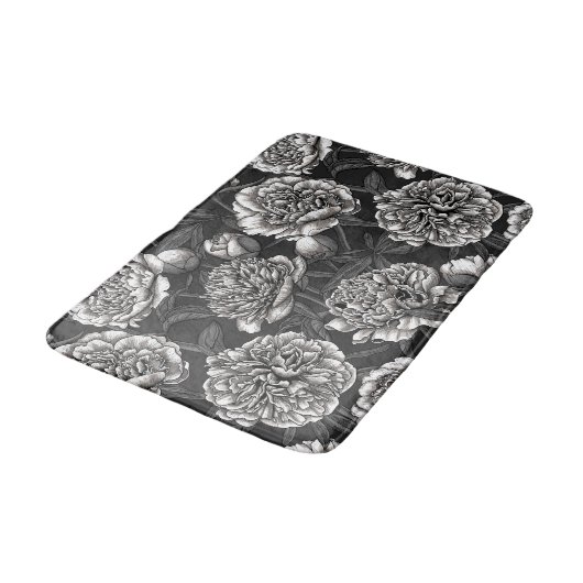 Blume aus weißem Pfirsich auf dunkelgrau Badematte (Schrägansicht)