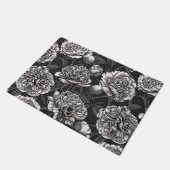 Blume aus weißem Pfirsich auf dunkelgrau Fußmatte (Schrägansicht)