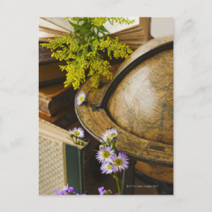 Blume mit antikem Globus und Büchern Postkarte