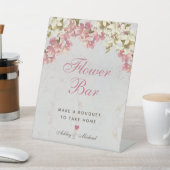 Blumenbar mit rosa Schrift und Orchideen auf Marmo Sockelschild (In SItu)
