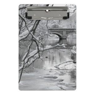 Bogen-Brücke über gefrorenem Fluss im Winter Mini Klemmbrett