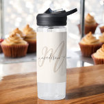 Boho Stylish Script Monogram und Name in Beige Trinkflasche<br><div class="desc">Eine niedliche feminine Wasserflasche mit boho-stylishen Schriftzeichen, in der Ihr Monogramm in einem großen modernen Schriftart in neutraler Bräune mit Ihrem Namen in einem handgeschriebenen handgeschriebenen Holzkohle-Schriftart auf beigem Hintergrund präsentiert wird. Das Aussehen ist modern und attraktiv und alles rund um Sie! IPersonalize mit Ihrem Namen und Initial. Stellen Sie...</div>