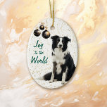 Border Collie Dog Joy to the World Christmas Keramik Ornament<br><div class="desc">Auf der Vorderseite dieses Holiday-Ornament ist ein Bild eines schönen schwarz-weißen Border Collie Hund sitzend vor einem goldenen Konfetti Hintergrund. An der links Seite hängen Zierelemente aus schwarzem und goldenem Baum. Im grünen Text steht "Joy to the World". Die Rückseite des Ornaments hat den gleichen Konfetti-Hintergrund und Textfelder, damit Sie...</div>