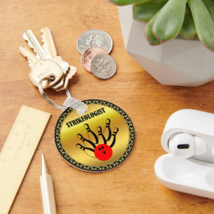 Bowlingball und Buttone mit dem Wort STRIKEOLOGIST Schlüsselanhänger