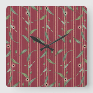 Branch of leaves on red wallpaper quadratische wanduhr