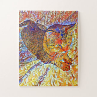 Braune getigerte Katze ruht auf einem bequemen Bet Puzzle