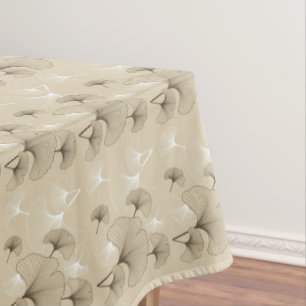 Braune und weiße Ginko-Blätter auf Tan Tischdecke