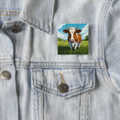 Braune und weiße Kuh auf einer Wiese stehend Button (Beispiel)