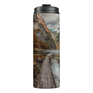 BRAUNER HOLZSTEG IN DER NÄHE EINES BERGES AM TAGE THERMOSBECHER