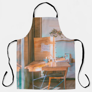 BRAUNER HOLZTISCH MIT WEISSEM DRUCKPAPIER SCHÜRZE