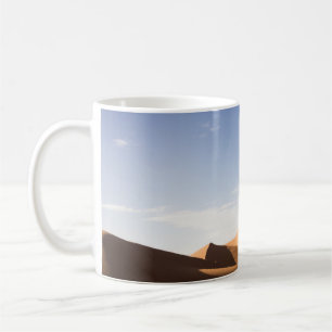 BRENNSAND UNTER BLAUEM HIMMEL WÄHREND DES TAGES KAFFEETASSE