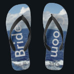 Bridge Groom Ocean Waves Blue Sky Badesandalen<br><div class="desc">Mein Original Fotografie & Grafik Design. Ein einzigartiger Bräuner Flip Flops nach Maß. Hübscher blauer Himmel mit flauschigen weißen Wolken, blauem Meer und weißen Schaumwellen. Unisex Flip Flops mit Braut und Bräutigam geschrieben in einem silberfarbigen Text, und Datum der Ehe in dunkelgrauem Text. PERSONALISIEREN Sie mit Ihrem Hochzeitstag (oder löschen...</div>