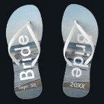 Bridge Ocean Waves Beach Sand Badesandalen<br><div class="desc">Hübscher blauer Himmel mit leicht flauschigen weißen Wolken, blaues Meer, abstürzenden Ozeanwellen und Strand Sand. Unisex Flip Flops mit Bride und Datum der Ehe geschrieben in einem weißen Text. PERSONALISIEREN Sie mit Ihrem Hochzeitstag (oder löschen Sie Text). Der Hochzeitstag ist im Sand geschrieben. Wählen Sie breite oder schlanke Gurte und...</div>