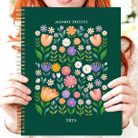 Bright Folk Art Floral Individuelle Name Planer<br><div class="desc">Dieses fröhliche Design besticht durch ein lebendiges, von der Volkskunst inspiriertes Blumenmuster mit bunten Blüten in Rosa, lila, Orange und Weiß vor einem tiefen grünen Hintergrund. Der personalisierte Name und das Jahr fügen eine einzigartige Touch hinzu, die es perfekt für Studenten, Profis oder alle, die spielerische und künstlerische Entwürfe Lieben....</div>