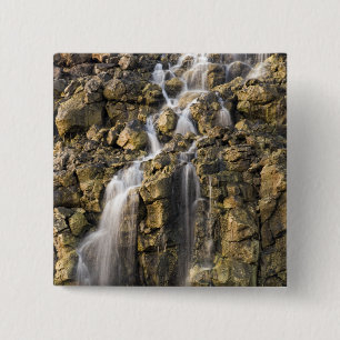 Brine fällt aus vulkanischem Gestein ab Button