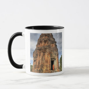 Buddhistischer Mönch, der vor der Tür des Tempels Tasse