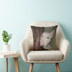 Bull Terrier schluckte unter einem schwarzen Kisse Kissen