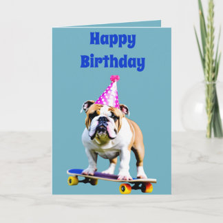 Bulldog, der einen Geburtstaghut auf einem Skatebo Karte