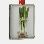 Bündel Frühlingszwiebeln auf weißem hackendem Ornament Aus Metall (Rechts)