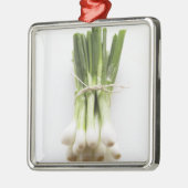 Bündel Frühlingszwiebeln auf weißem hackendem Ornament Aus Metall (Links)