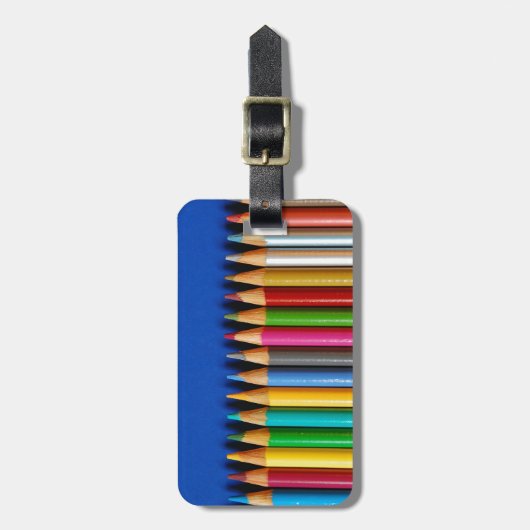 Bunte Bleistiftzeichenstifte auf blauem Gepäckanhänger (Vorderseite vertikal)
