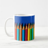 Bunte Bleistiftzeichenstifte auf blauem Kaffeetasse (Links)