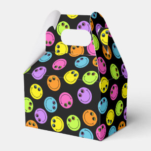 Buntes lächelndes Emoji stellt auf Schwarzem Geschenkschachtel
