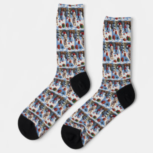 Cairn Terrier läuft im Schnee mit Weihnachtsmütze Socken