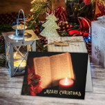 Candle Poinsettia Alte Bibel Feiertagskarte<br><div class="desc">Senden Sie Ihren Freunden und Ihrer Familie dieses Jahr eine einzigartige Weihnachtskarte. Ein schwarzer Hintergrund Set die Bühne für eine Bibel, die sich dem Buch Luke zugewandt hat, mit einer beleuchteten Stimmkerze, und eine Poinsettia vervollständigt das Gefühl. Der "Frohe Weihnachten" Gruß kann auf Ihre Bedürfnisse angepasst werden, um Ihren Anzug....</div>