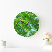 Canopy of Green, Leafy Branches with Blue Sky Große Wanduhr (Zuhause)