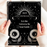 Celestial Sun Moon Stars Custom Manifestation Planer<br><div class="desc">Dieses faszinierende Design zeichnet sich durch himmlische Elemente wie Sonne, Mond, Sterne und blühende Sonnenblumen aus, die alle Set vor einem kühlen schwarzen Hintergrund bilden. Die motivierend Phrase "Lass the Universe Be Your Guide" inspiriere Fokus und Erscheinungsbild, was dieses Design sowohl funktionell als auch ermächtigend macht. Personalisiert mit einem individuelle...</div>