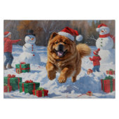 Chow Chow läuft im Schnee mit Weihnachtsmütze Schneidebrett (Vorderseite)