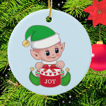 Christmas Green Elf Keramik Ornament<br><div class="desc">Niedliche Weihnachtself mit Geschenkboxen auf hellblauen Ornament. Man glaubt,  dass die Elfen kleine Engel der Erde sind. Joy Text kann mit einem kurzen Text oder Monogramm personalisiert werden.</div>