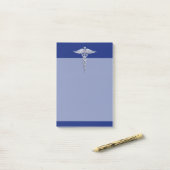 Chrom mag Caduceus-medizinisches Symbol auf blauem Post-it Klebezettel (Auf Schreibtisch)